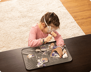 A BratMat protecting a wooden coffee table during craft time