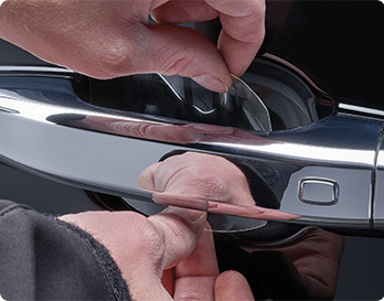 ScratchProtection film being installed to protect the paint behind a car's door handle
